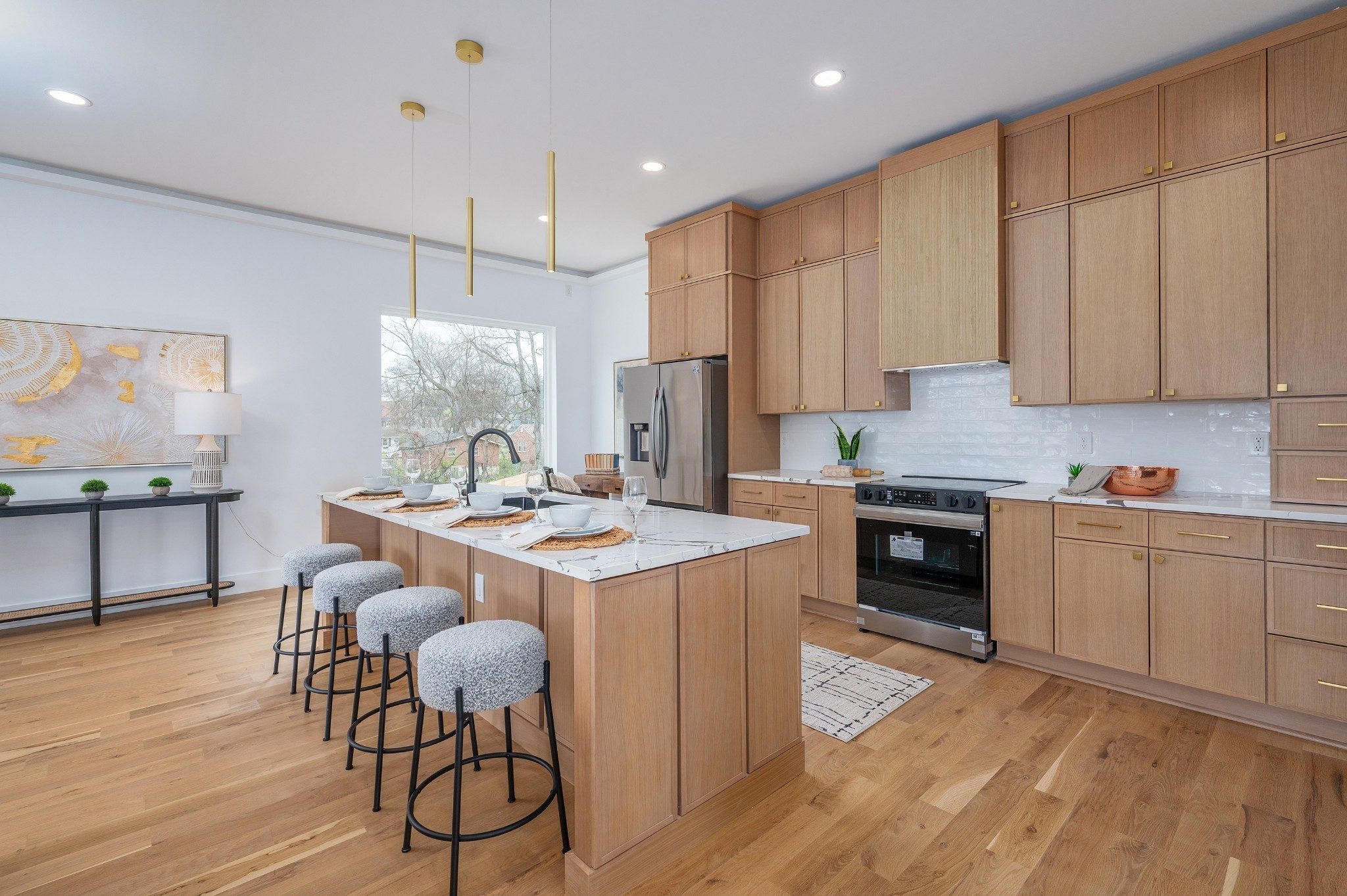 Kitchen with light wood cabinets, a long island with stools, and stainless appliances at 1001 Glenview Drive in East Nashville