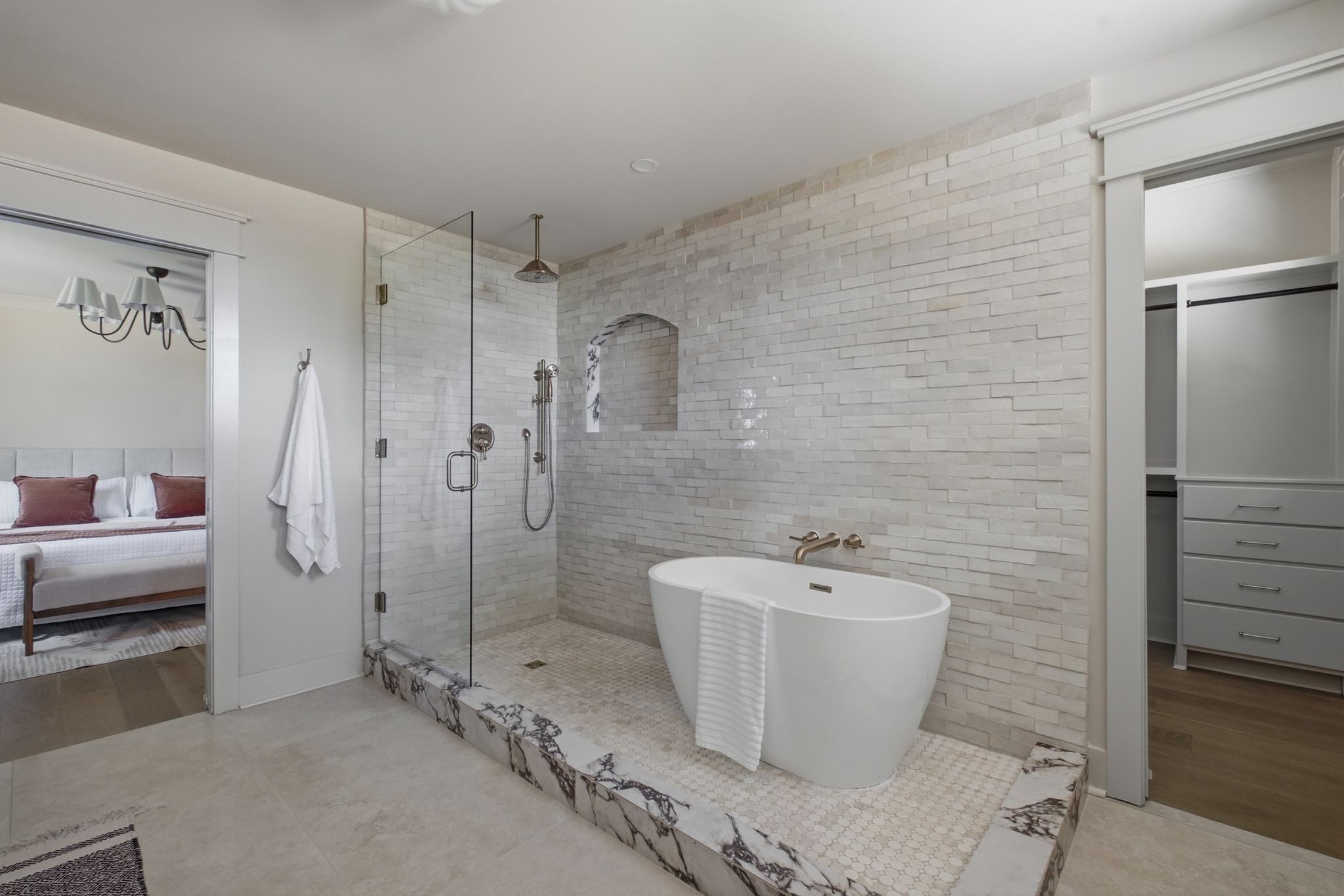 Primary bath with a freestanding tub, a glass shower, and tile walls at 1207 Shelton Avenue in East Nashville
