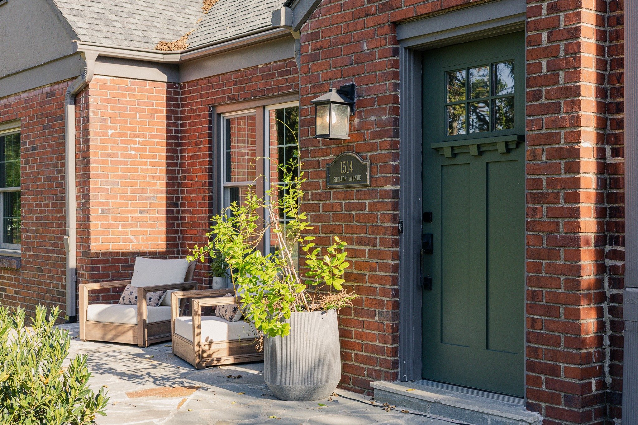 Flagstone front patio with chairs beside the green front door at 1514 Shelton Avenue in East Nashville