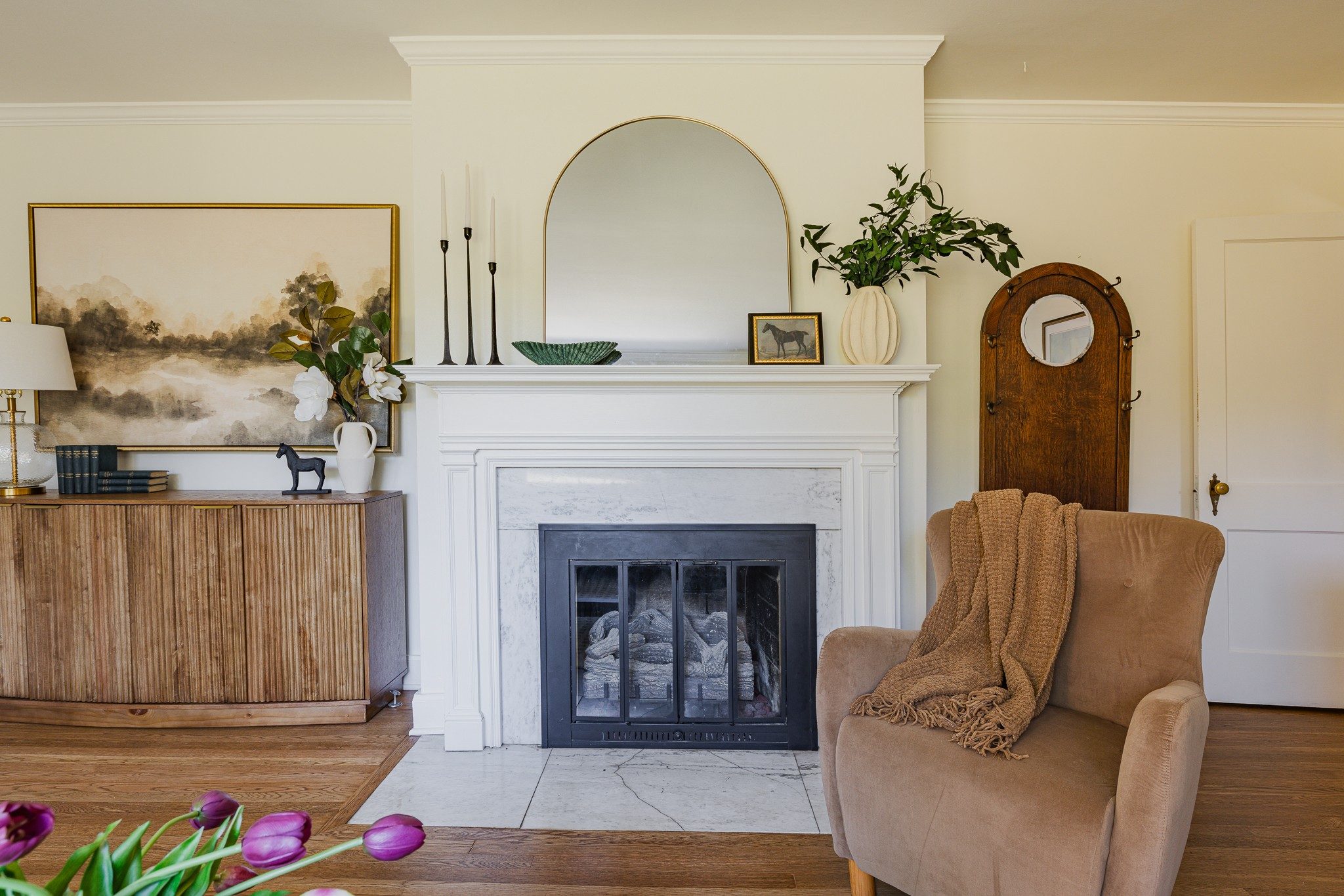 Living room with a white mantel gas fireplace and refinished hardwood floors at 1514 Shelton Avenue in East Nashville