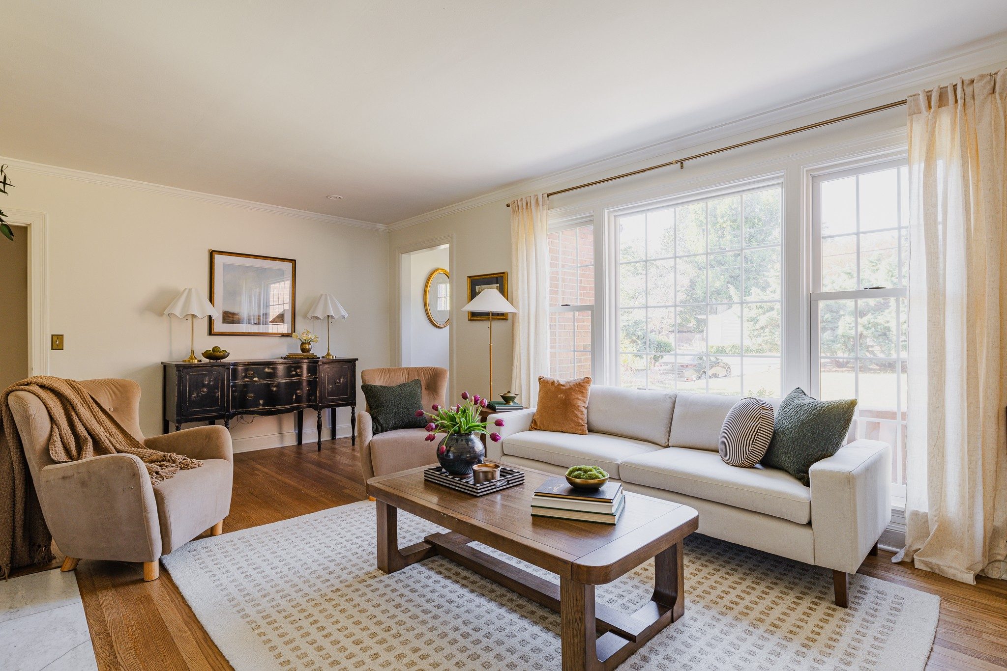 Sun filled living room with a large front window, a sofa, and hardwood floors at 1514 Shelton Avenue in East Nashville