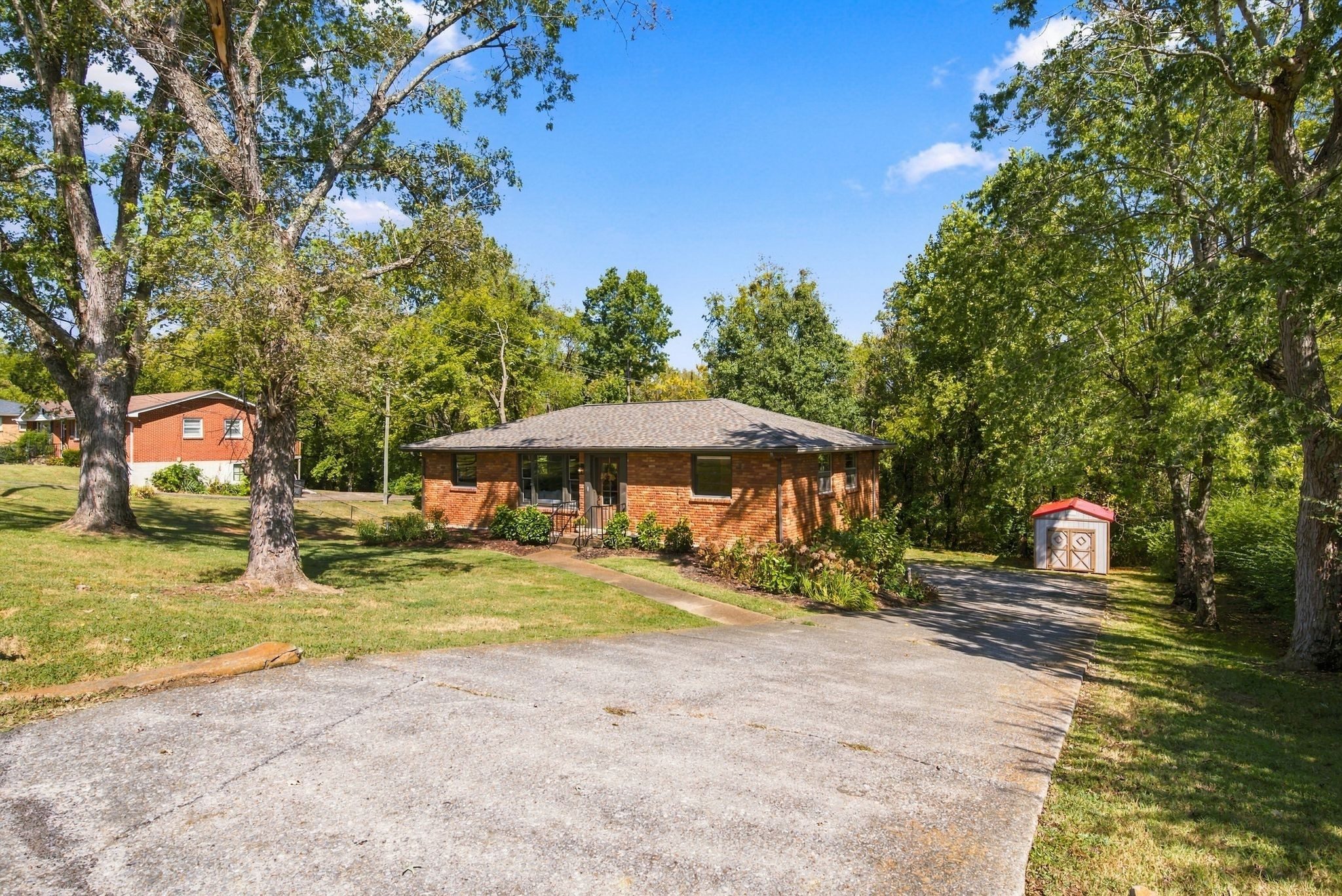 Long driveway leading back to the brick ranch and a storage shed on the half acre lot at 1829 Willow Springs Drive in East Nashville
