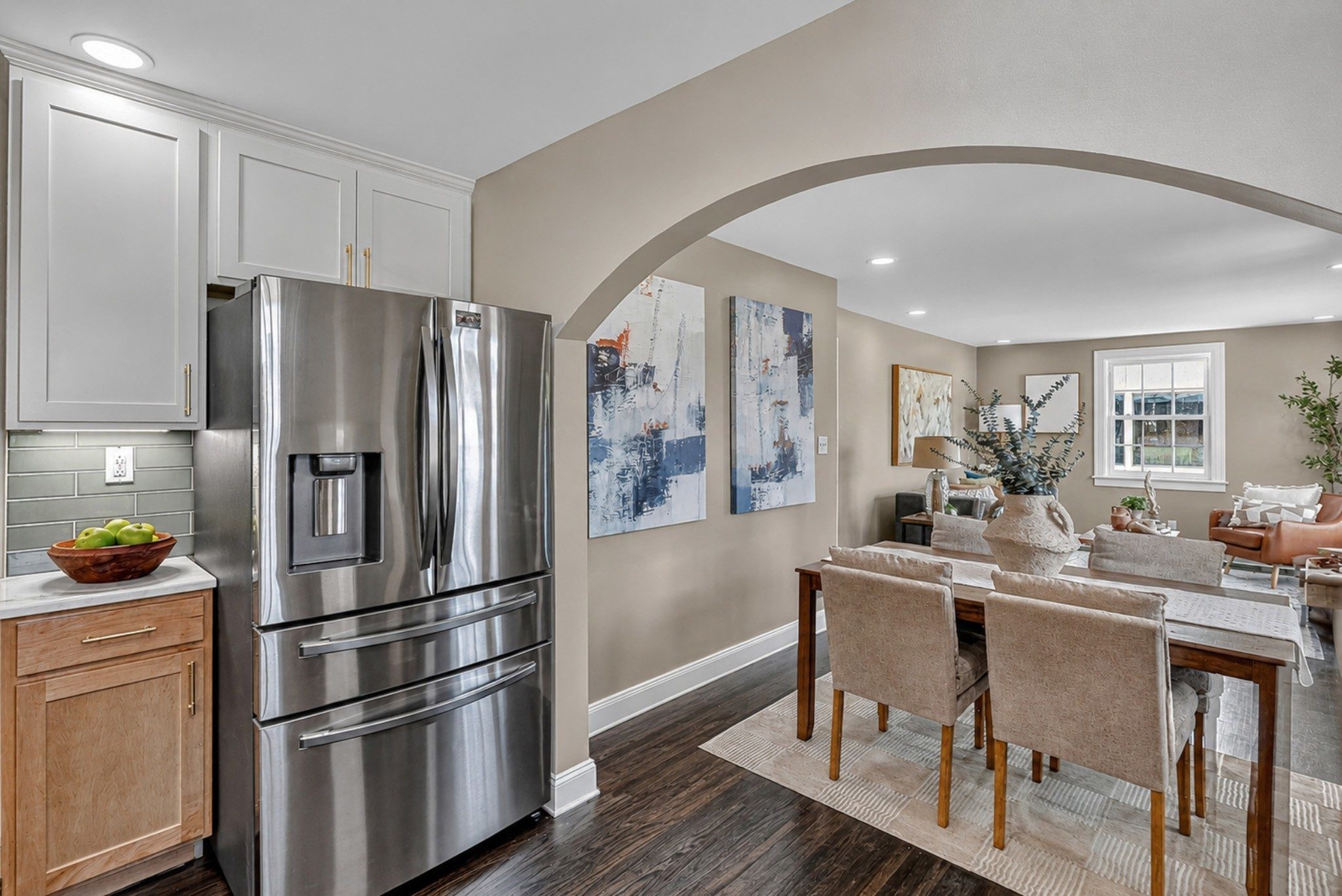 Arched opening from the kitchen into the dining area with dark wood floors at 2217 Pinewood Road in East Nashville
