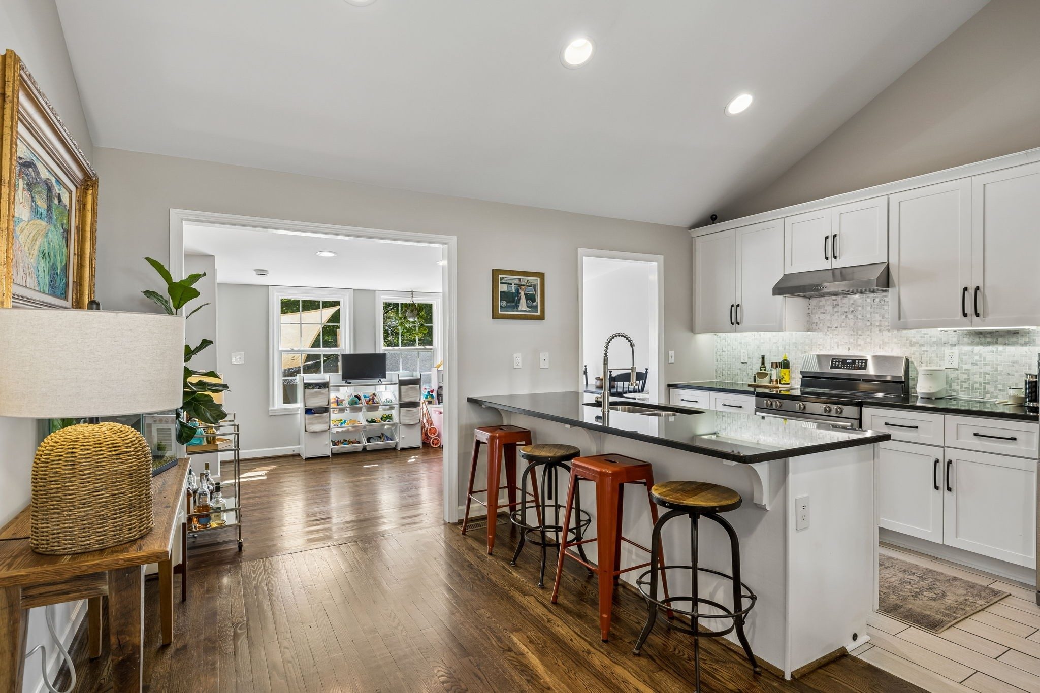 Kitchen with white cabinets, a dark countertop island with bar stools, and recessed lights at 3812 Inglewood Circle North in East Nashville