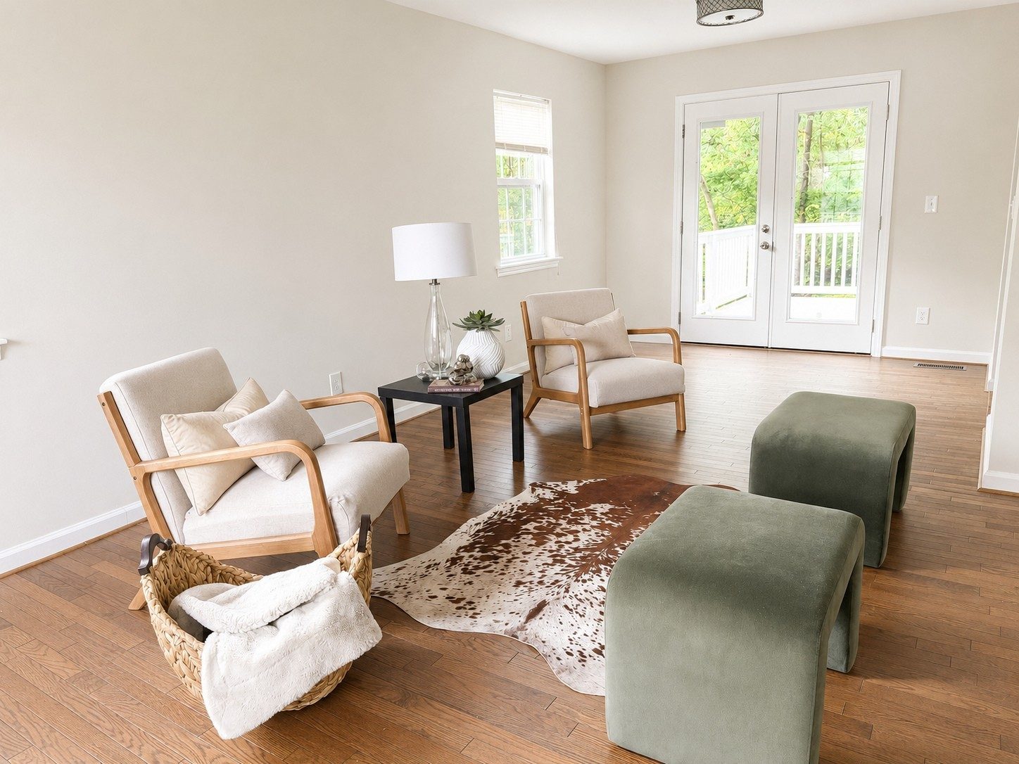 Living area with wood floors, French doors to a deck, and staged chairs and ottomans at 503 Ben Allen Road in East Nashville