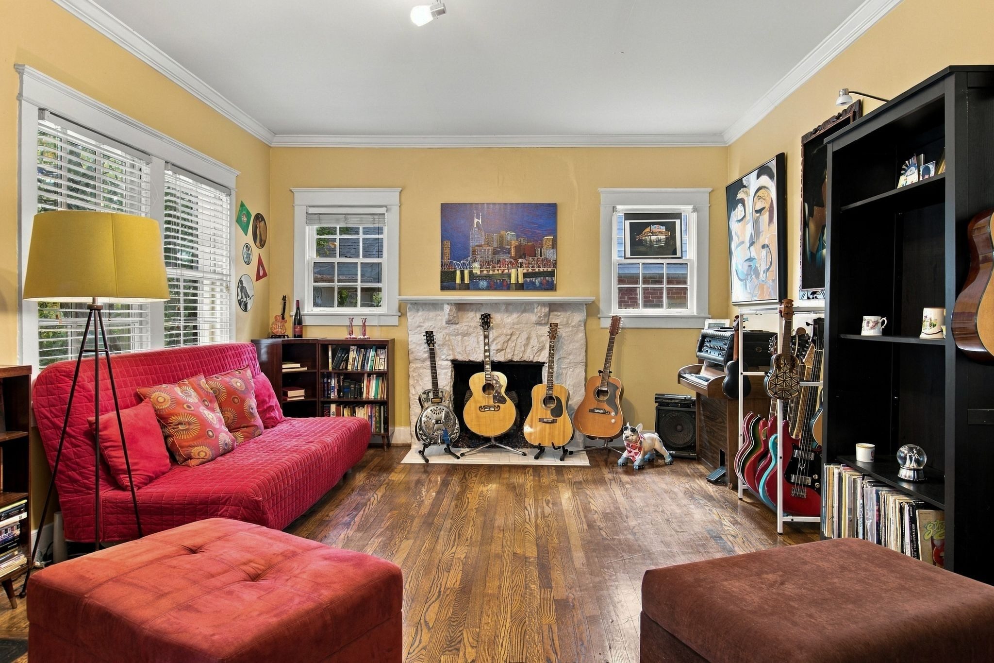 Living room with hardwood floors, a fireplace, and large windows at 711 Shelby Avenue in East Nashville
